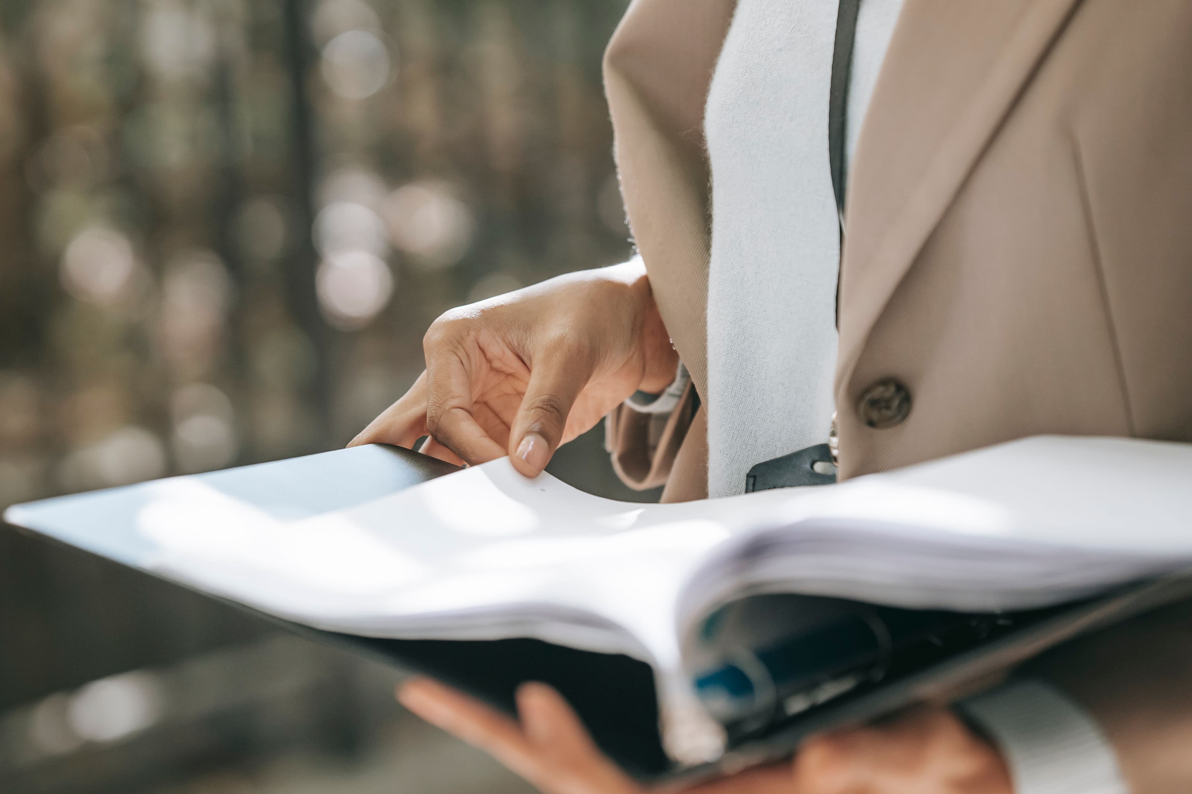 Persona hojeando una carpeta con documentos